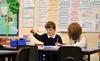 Teacher recording observations of student working.
